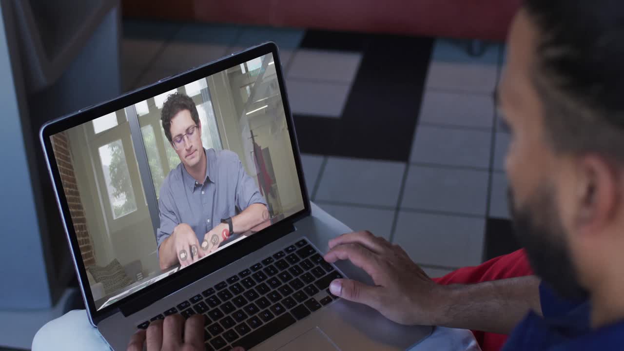 hombre de oriente medio teniendo una videollamada con un colega masculino en una computadora portátil