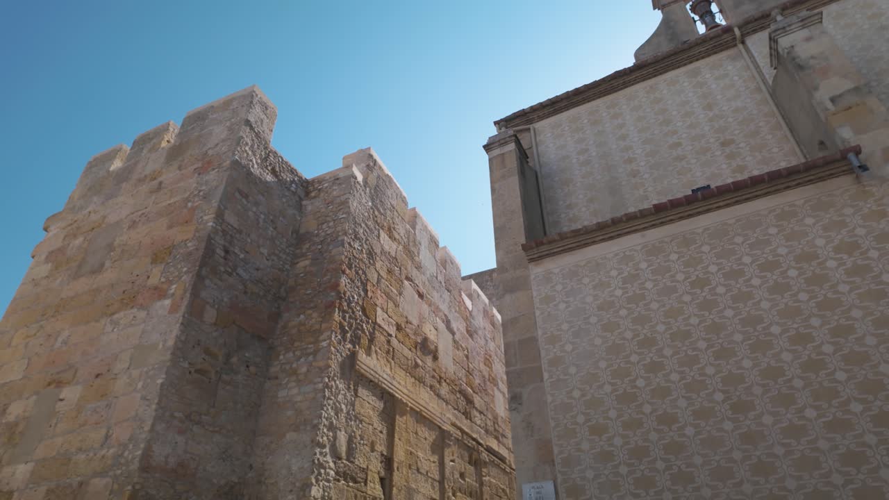 Ancient stone tower in Tarragona, Spain, showcasing medieval architecture under a bright sky