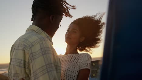 couple embracing each other near pickup truck at beach 4k