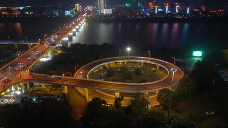 night time illuminated changsha city downtown riverside traffic bridge road junction aerial panorama 4k china