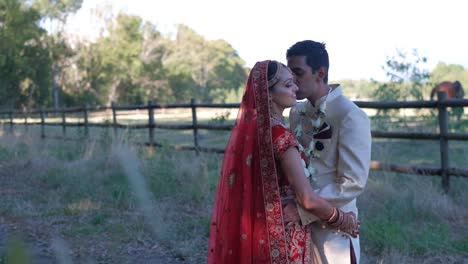 hindu groom kissing bride during wedding ceremony photoshoot - wide shot