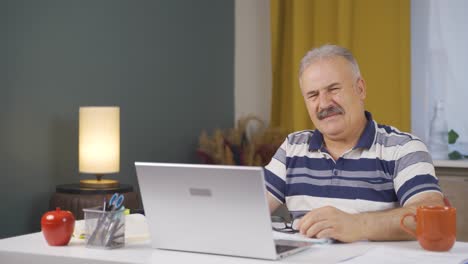 Home-office-worker-old-man-looking-at-camera-with-disgust-and-hatred.