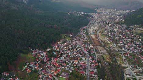 Vista-Aérea-De-La-Ciudad-De-Busteni-En-Las-Estribaciones-De-La-Montaña-Con-El-Río-Prahova-En-Muntenia,-Rumania