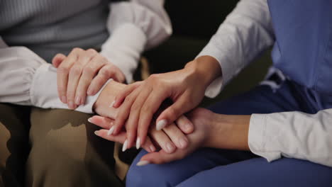 a nurse provides comforting support to an elderly person by holding their hands