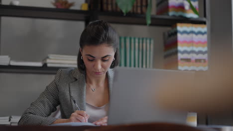 mujer trabajando desde casa usando una computadora portátil mientras lee un mensaje de texto. mujer usando una computadora portátil estudiando en la oficina. mujer de negocios escribiendo una computadora portátil en el lugar de trabajo mujer trabajando en el teclado de mano de la oficina en casa.