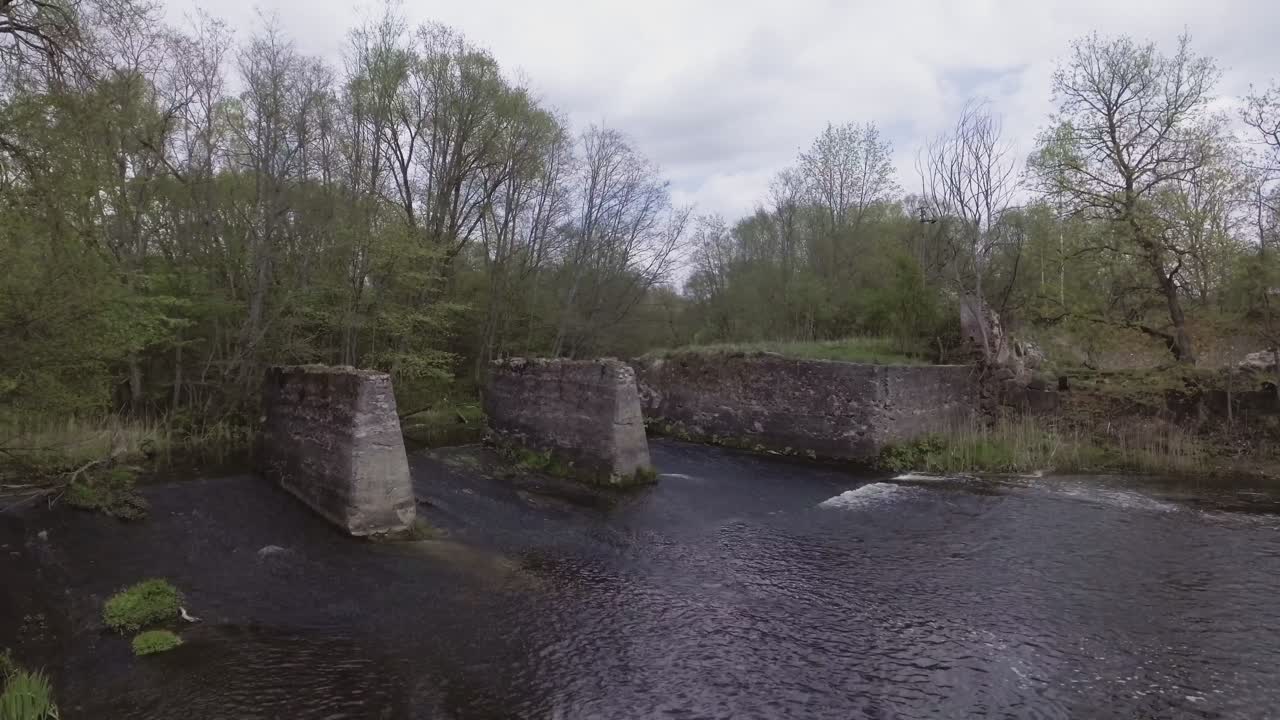 Remains of the watermill of fragments of Musninkai (Musninkeliai) manor homestead. 4K aerial fast dolly-in