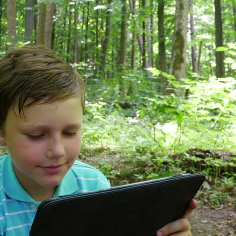 boy with tablet in the forest