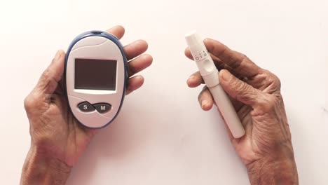 elderly person performing blood glucose test