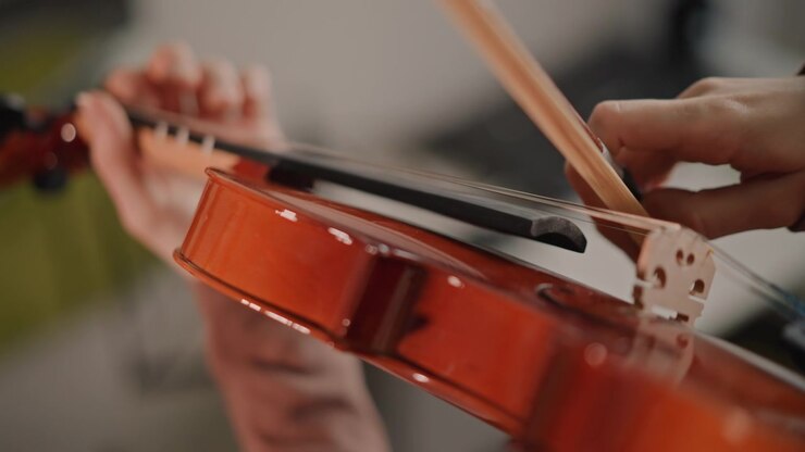 Tecnica dettagliata dell'archetto sulle corde del violino, primo piano della pennellata dell'archetto e della coordinazione della mano, movimento lento e deliberato che mostra dinamiche e articolazione, sessione di pratica con istruzioni mirate simili a quelle di un coach.