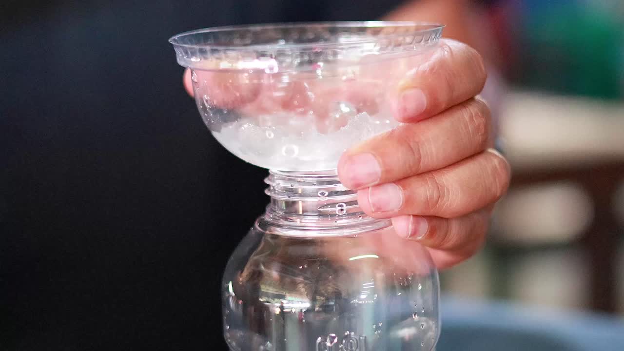 시장에서 병에 얼음을 부어 넣는 것