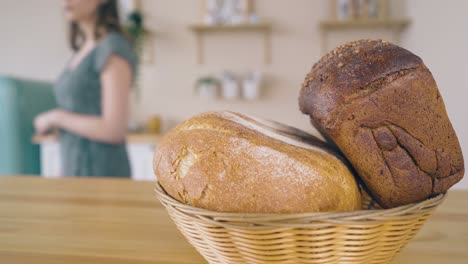 lady carries organic bread loaves to stylish table closeup