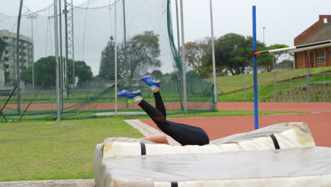 Side-view-of-Caucasian-female-athlete-practicing-high-jump-at-sports-venue-4k