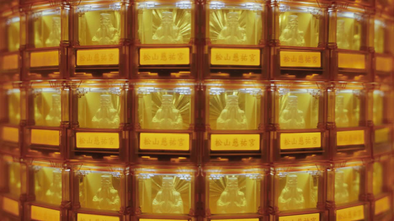 A symmetrical close-up of many golden Buddha statues glowing in illuminated niches at Ciyou Temple in Taiwan, symbolizing devotion, peace, and spiritual reverence in a sacred Buddhist space