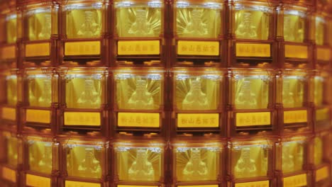 a symmetrical close-up of many golden buddha statues glowing in illuminated niches at ciyou temple in taiwan, symbolizing devotion, peace, and spiritual reverence in a sacred buddhist space