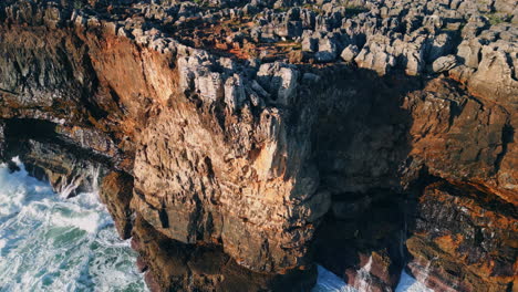 high rough cliffs scenery washing by foamy stormy waves. aerial rocky seashore