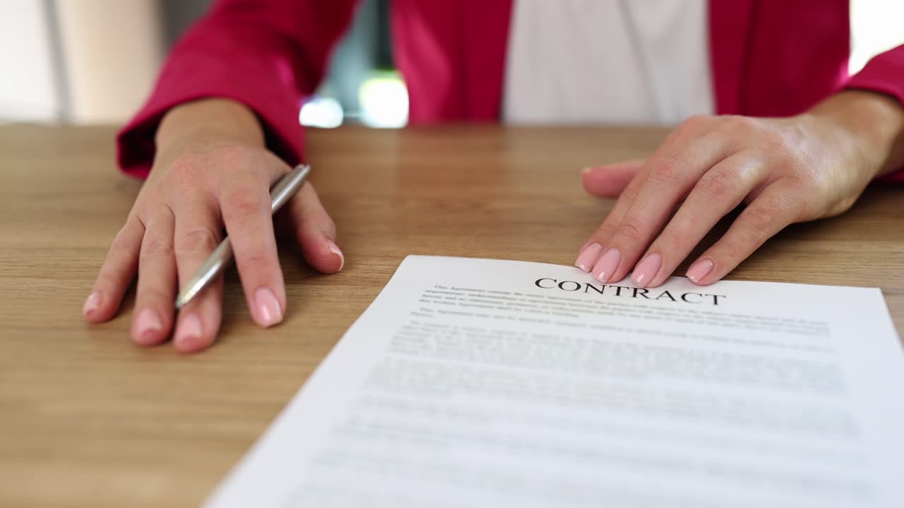 Hands on a Contract Document with a Pen