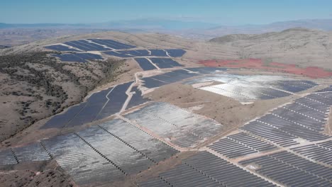 drone mega photovoltaic solar power park farm panel rural hills reflect sunlight