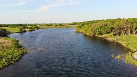 Flying-low-near-the-water-of-a-pond,-reservoir,-a-soil-conservation-sight