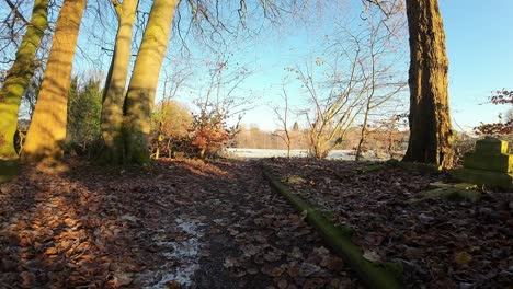 FPV-flying-around-headstones-in-snowy-autumn-sunrise-churchyard-graveyard-during-golden-hour