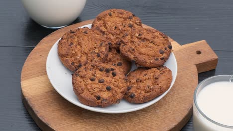 toma unas galletas con chocolate, un vaso de leche, en cámara lenta. cierra.