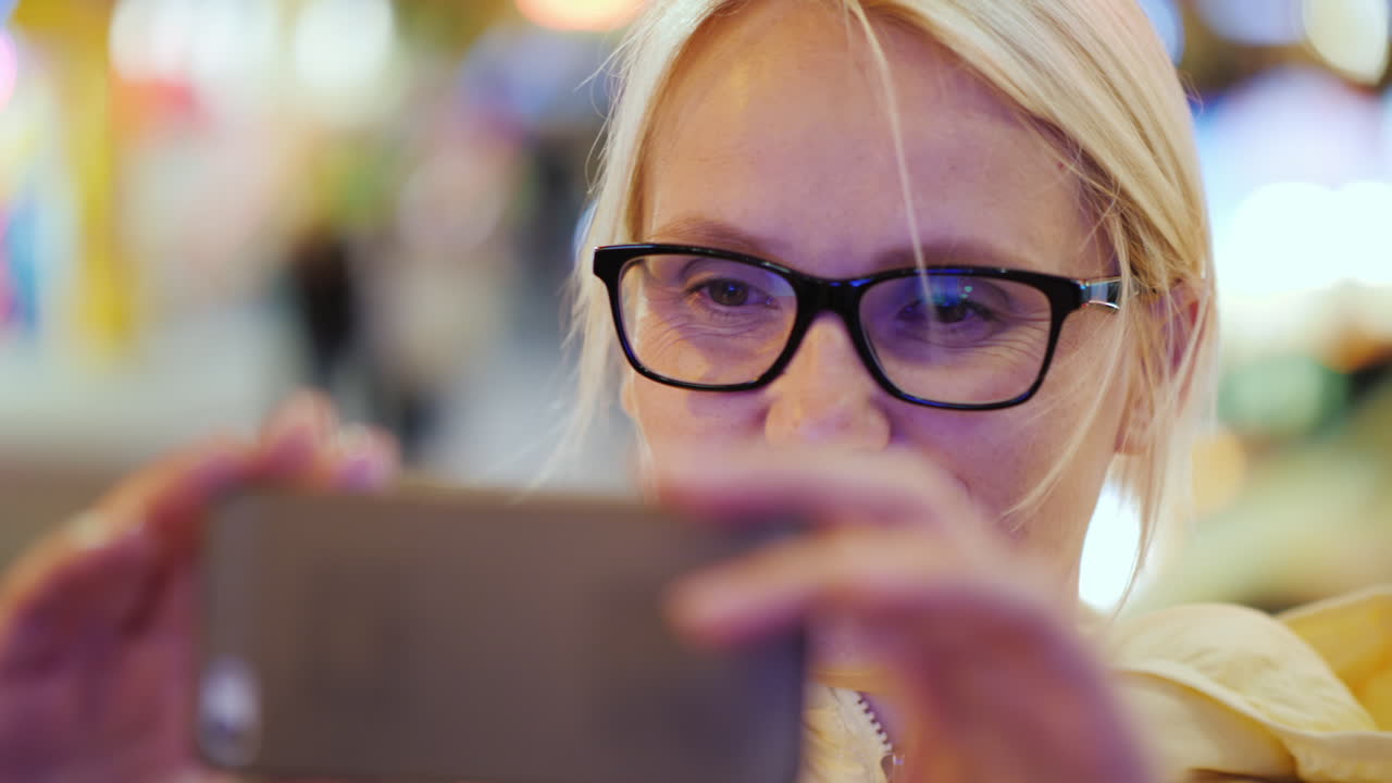 mujer tomando fotos en la ciudad por la noche