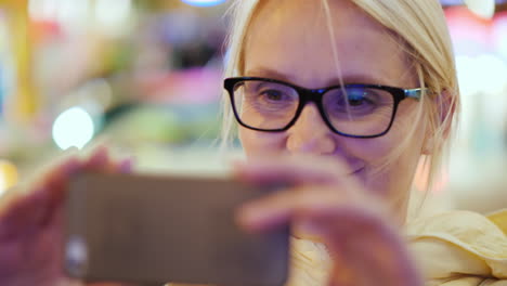 Woman-Taking-Photo-in-City-at-Night