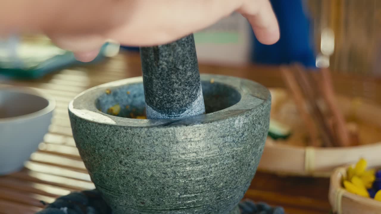 Geleneksel pişirme tekniklerini ve otantik Tayland yemeği hazırlığını vurgulayan, Tayland papaya salatası hazırlamak için taze malzemeleri havan ve el ile ezen bir adam