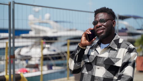 man talking on phone at harbor