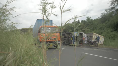 un camión que transportaba un contenedor de almacenamiento en frío se volcó en un accidente debido a un sobreviraje en una sección ghat cuesta abajo en una carretera india en cámara lenta de 4k