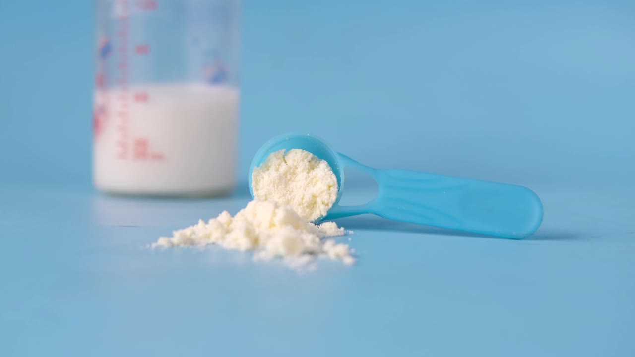 fórmula para bebés con cuchara medidora y botella