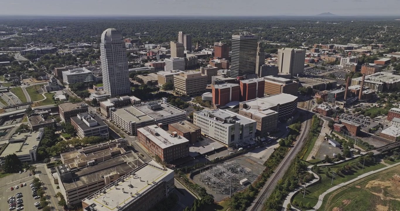 Sobrevuelo aéreo v26 de Winston-Salem, Carolina del Norte, a lo largo de Research Parkway, pasando senderos y parques, hacia el horizonte del centro. Filmado con Mavic 3 Pro Cine - 1 de octubre de 2023