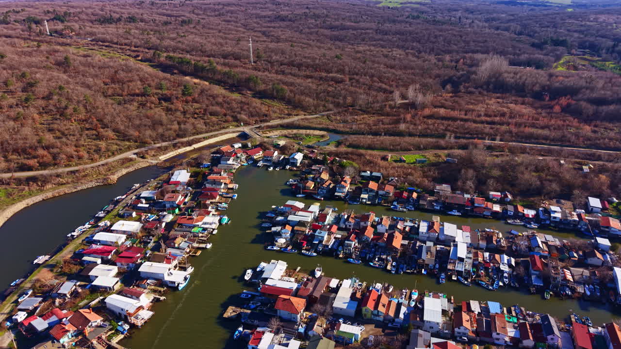 Mensen wonen in huizen aan het water met boten en bomen, van bovenaf gezien, een dorp tonend in een natuurlijke omgeving op een zonnige dag