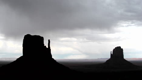 ominous storm clouds move quickly over mitten buttes in monument valley utah