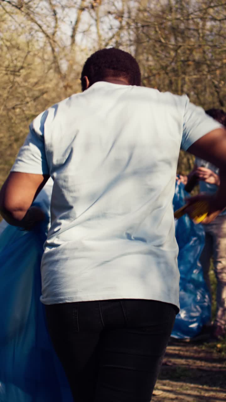 Woman Volunteer Collecting Garbage with a Group in the Park