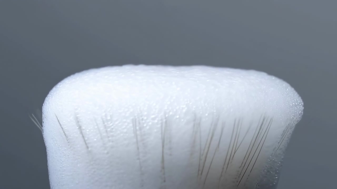 Extreme close view of brush tip as foam forms into rounded dome, gains textured bubbles, flattens, consolidates, then recedes to reveal fine bristles, soft highlights, and hygienic grooming detail