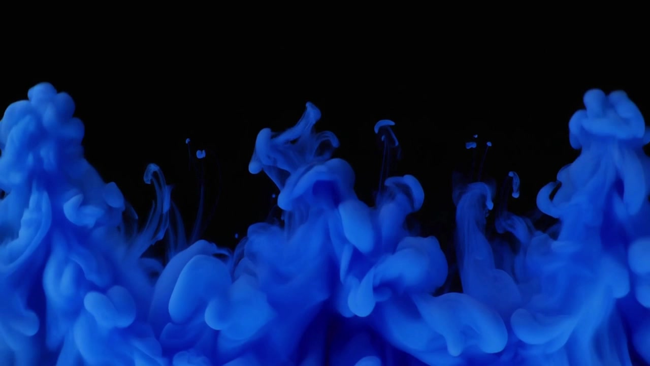 Inchiostro blu che si diffonde nell'acqua su sfondo nero
