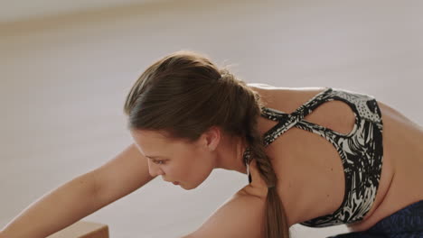 hermosa mujer de yoga ejercitando un estilo de vida saludable practicando pose de gran ángulo sentado de lado disfrutando del entrenamiento en el estudio de entrenamiento ejercicio de respiración consciente