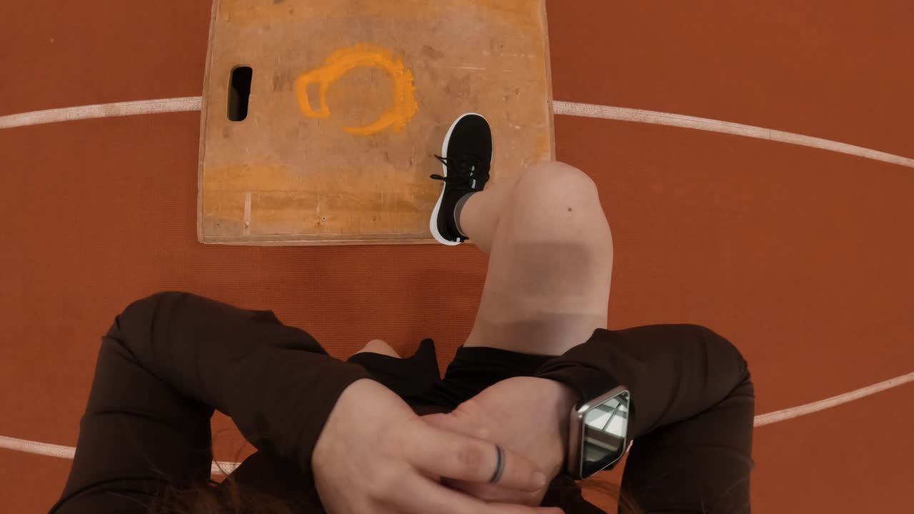 First-person view of an athlete's feet on a starting block on an indoor running track