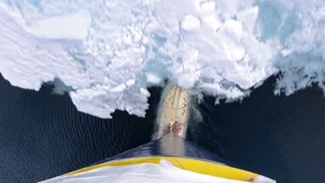 Tilt-up-bulbous-bow-point-of-view-of-an-icebreaker-ship-plowing-through-sea-ice-in-Hinlopen-Strait-in-Svalbard-Archipelago-Norway