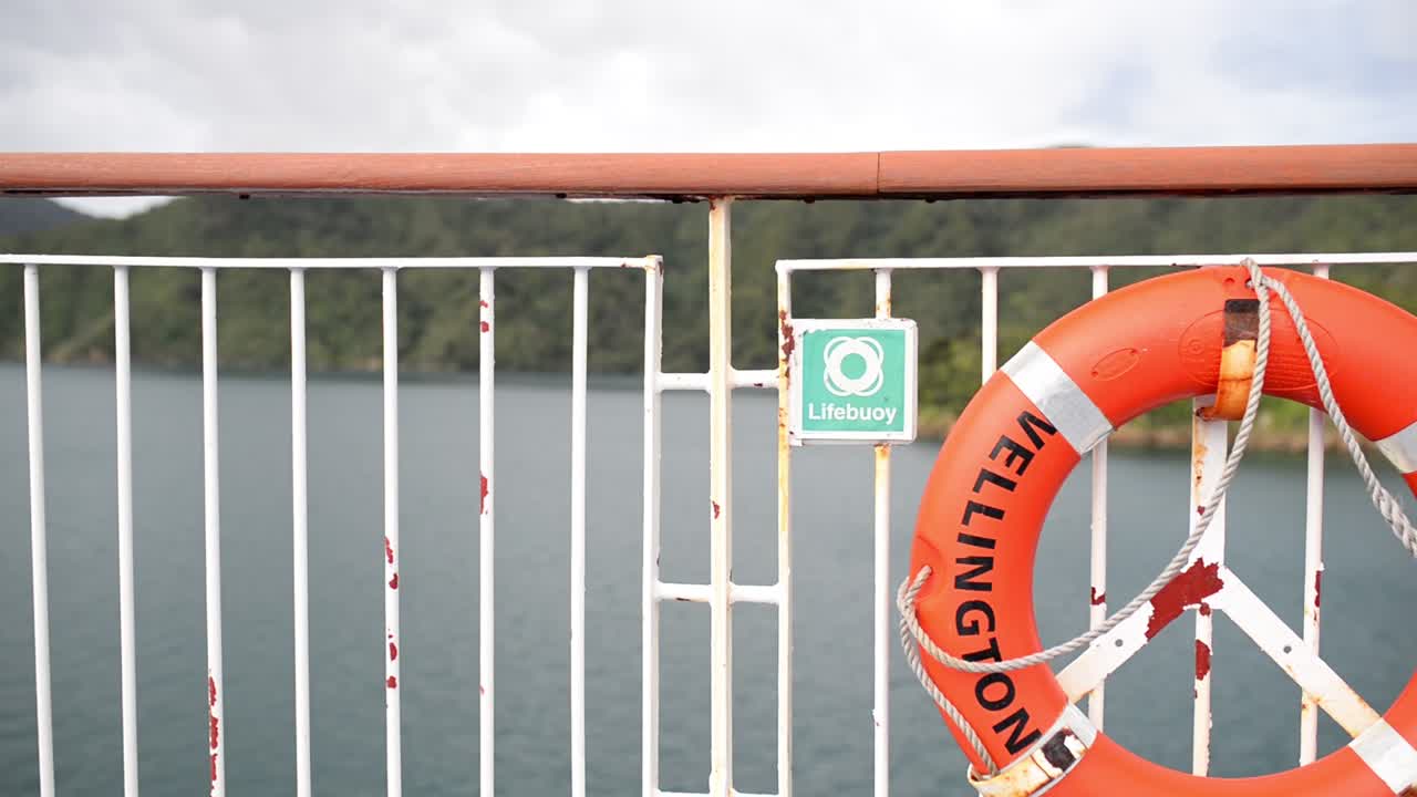 짠 바닷바람에 조용히 움직이는 주황색 구명 부표의 로프