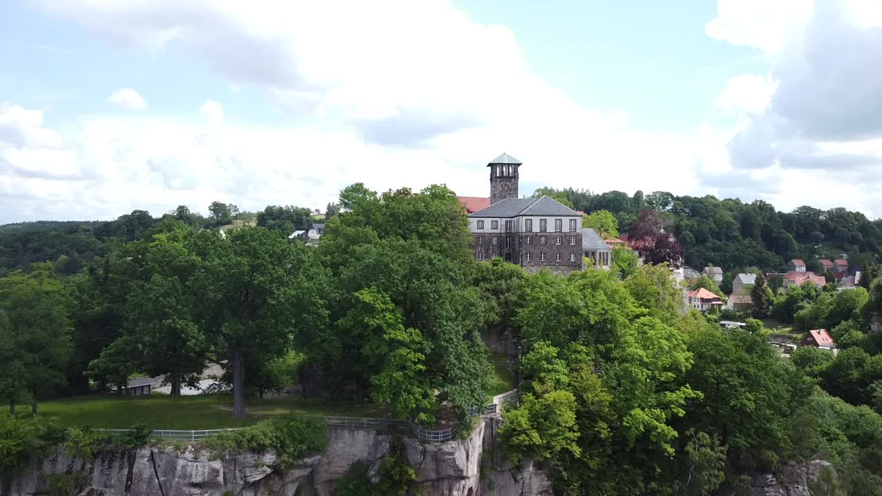 drone descending with view on hilltop village in central Europe on a bright and cloudy day in eastern Germany