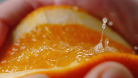 close-up of orange bursting while being squeezed