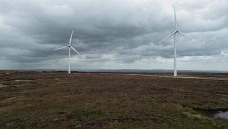 drone aerial video footage of a wind farm and wind turbines turning in the wind