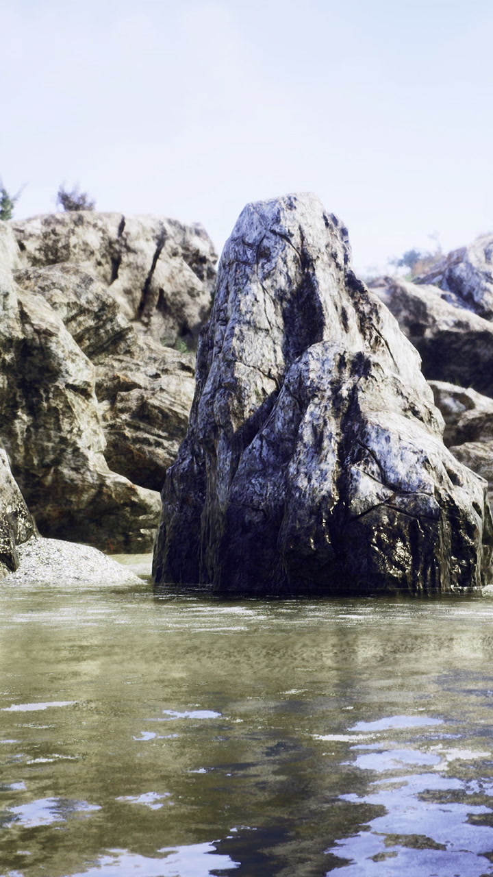 Rock formation stands tall in shallow water near the shore during the day