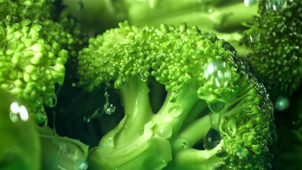Primo piano di broccoli verdi freschi con gocce d'acqua al rallentatore