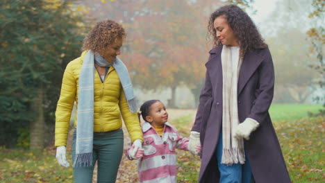 Lächelnde-Weibliche-Mehrgenerationenfamilie,-Die-Gemeinsam-In-Der-Herbstlichen-Landschaft-Spazieren-Geht-Und-Grimassen-Zieht