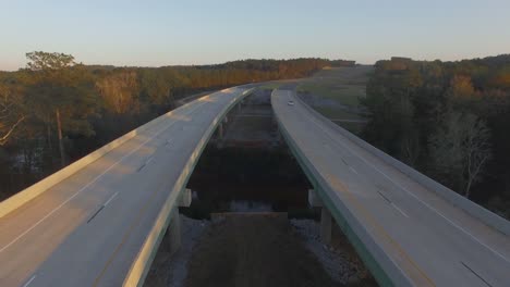 Car-driving-on-rural-two-lane-road-bridge-over-small-river