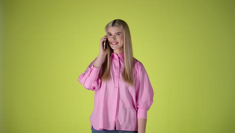 Cute-blonde-woman-talking-on-phone,-smiling-and-nodding-head,-studio-shot