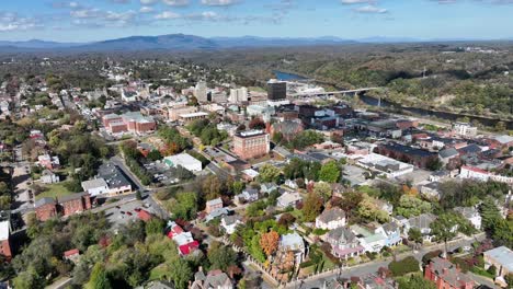 american downtown and neighborhood with houses and homes. sunny day in autumn with flowing river in background. aerial wide shot. top view.