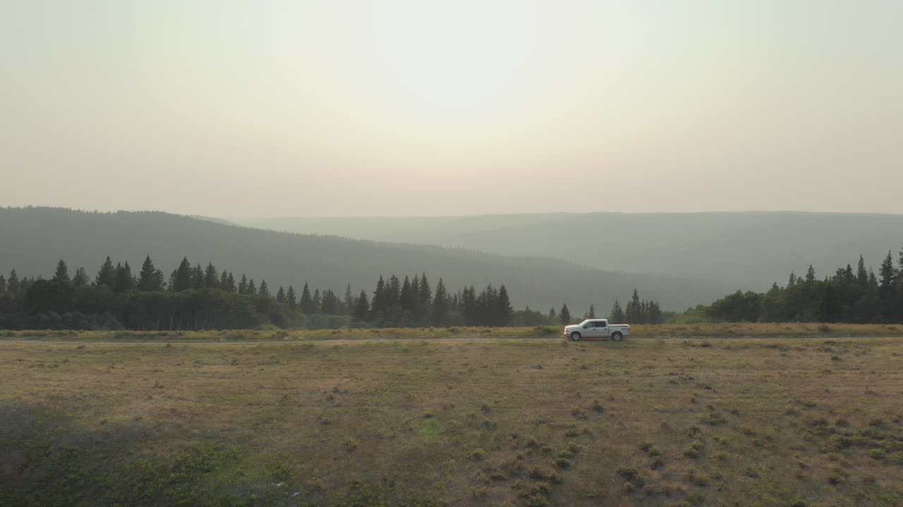광활한 야외 풍경을 통해 운전하는 흰색 픽업 트럭, 캐나다 서스캐처원